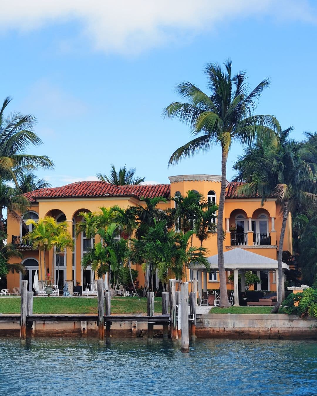 waterfront-orange-house-palm-trees Photo of waterfront home lined with palm trees